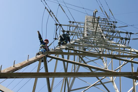 Workers executing repairs at power transmission lines