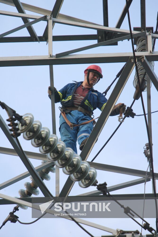 Worker executing repairs at power transmission lines