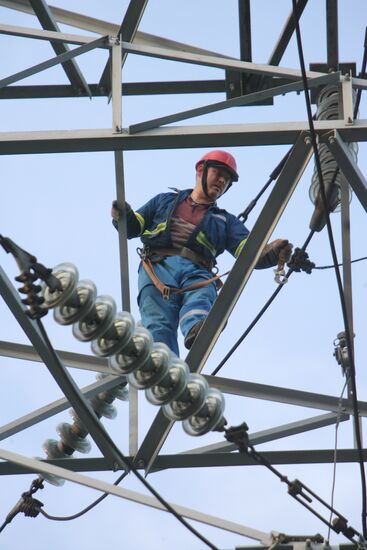 Worker executing repairs at power transmission lines