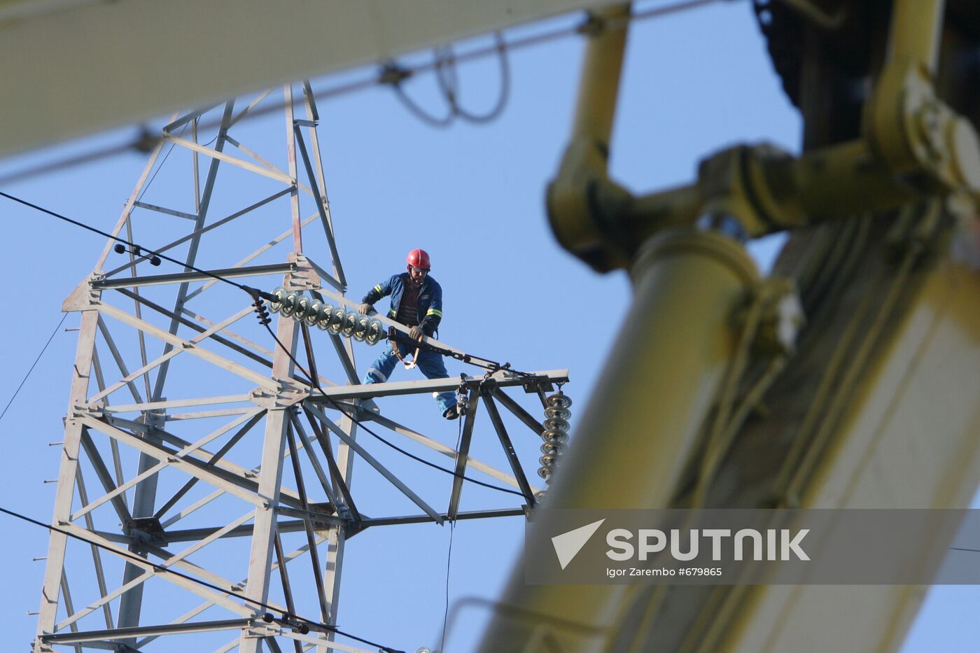 Worker executing repairs at power transmission lines