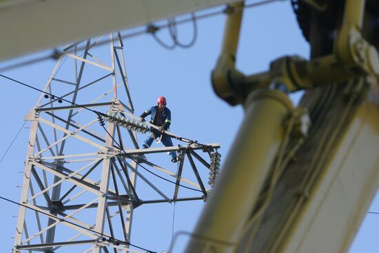 Worker executing repairs at power transmission lines