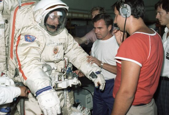 COSMONAUT VIKTORENKO EXAMINING SPACE SUIT 