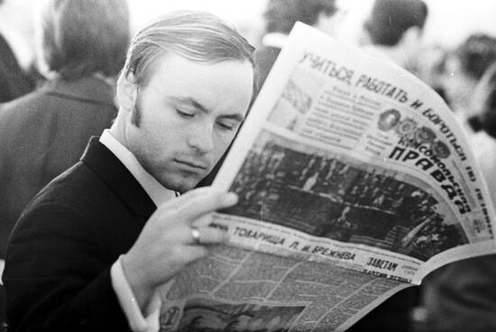 Young man reading newspaper