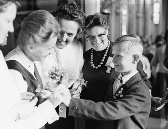 Pioneer Viktor Kosykh giving flowers to delegates of the Moscow World Women's Congress