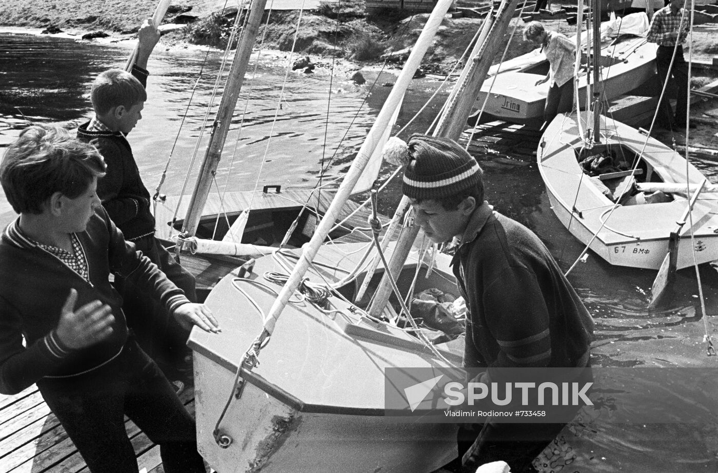 Boys setting yacht afloat