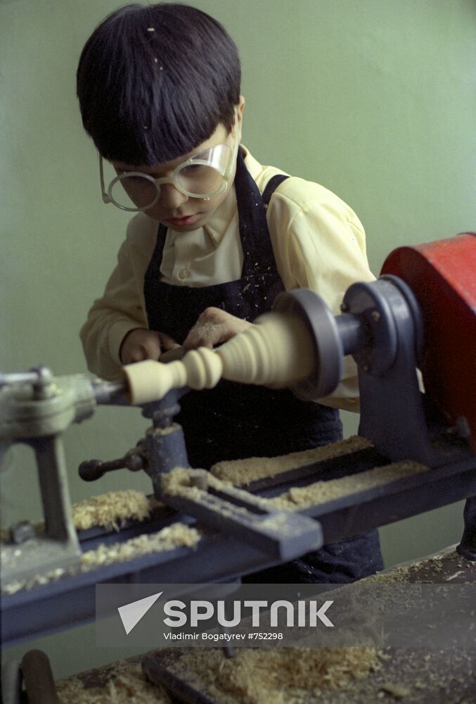 Boy working on a turning machine