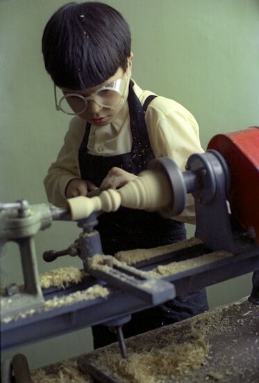 Boy working on a turning machine