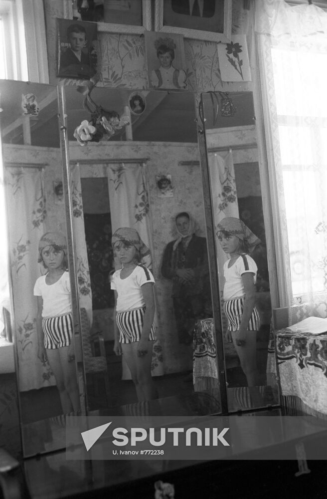 Girl by a three-panel mirror