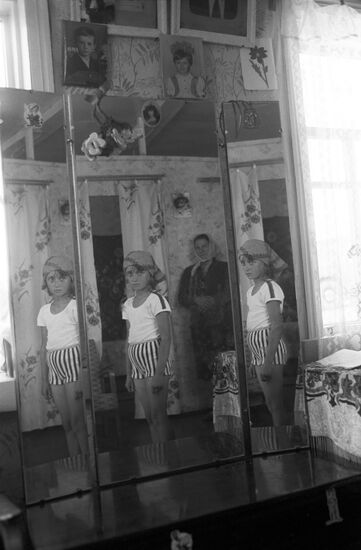 Girl by a three-panel mirror