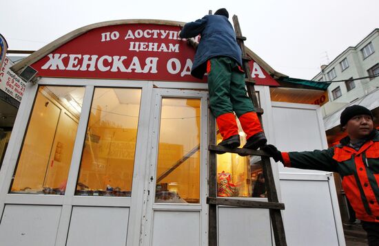 Com-Service's employees disassemble market stall