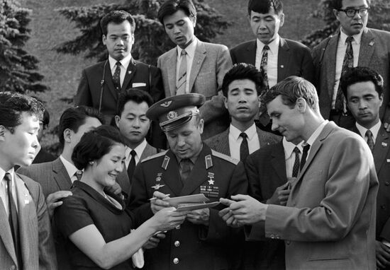 Space pilot Leonov giving autographs to Japanese youth delegation 