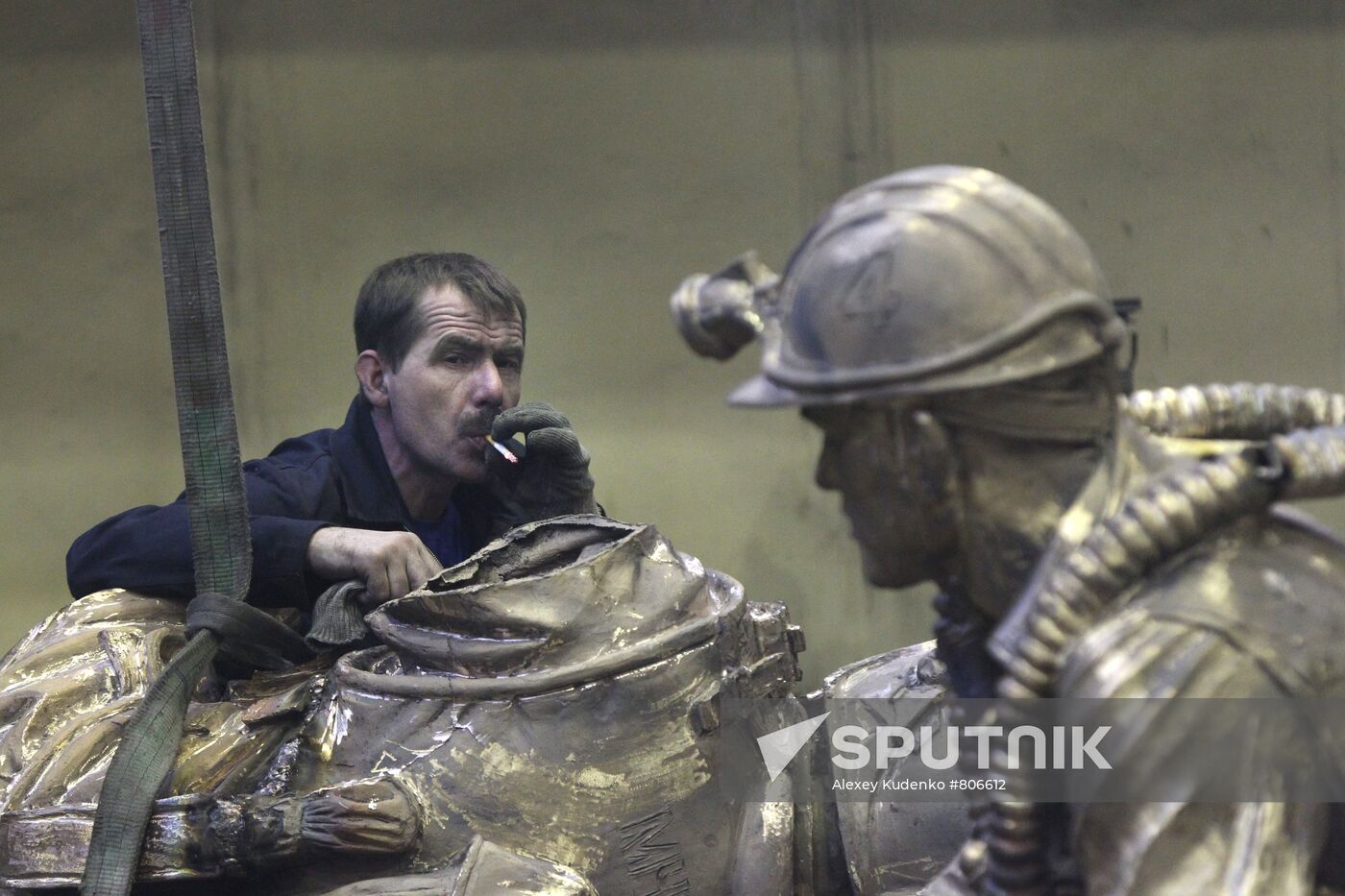 Worker with Monument to Emergencies Ministry employees