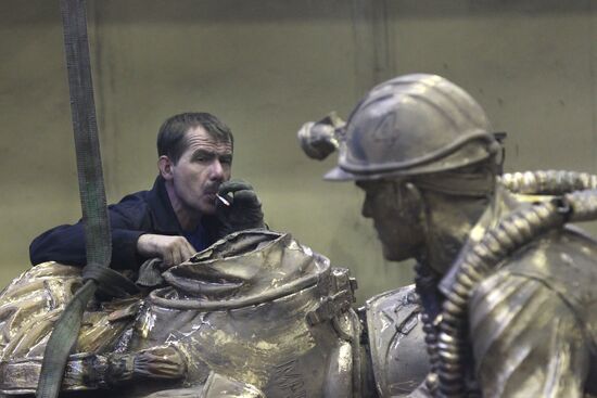 Worker with Monument to Emergencies Ministry employees