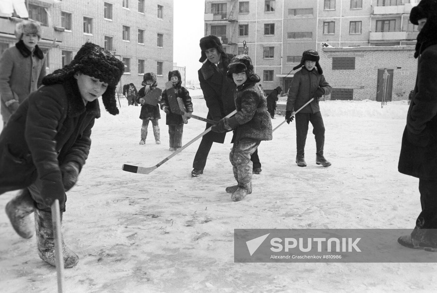 Boys playing hockey in their yard