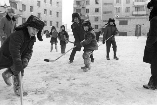 Boys playing hockey in their yard
