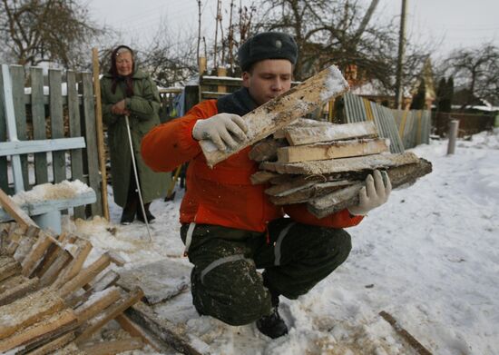 Volunteers helping pensioners to stack firewood for winter