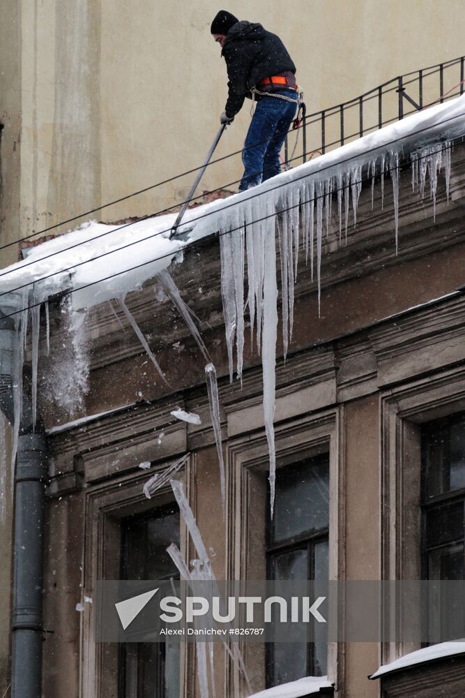 Communal services officer clears roof of icicles