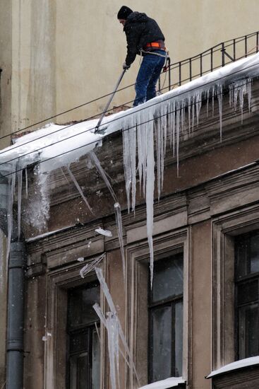 Communal services officer clears roof of icicles