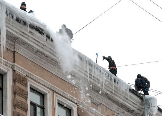 Communal services officers clear roofs of icicles
