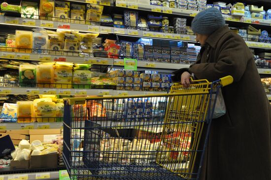 A woman choosing cheese in the Lenta hypermarket