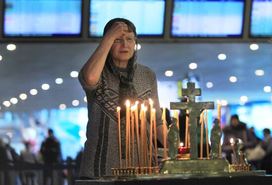 Woman praying at memorial service for blast victims