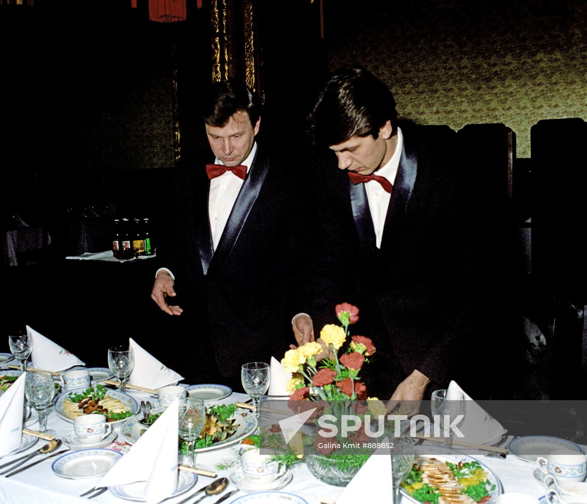 Waiters arranging tableware