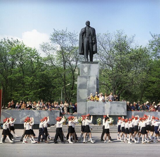 Young Pioneers marching in front of monument to Vladimir Lenin