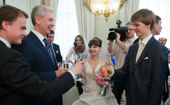 Sergei Sobyanin presents marriage certificate to newlyweds