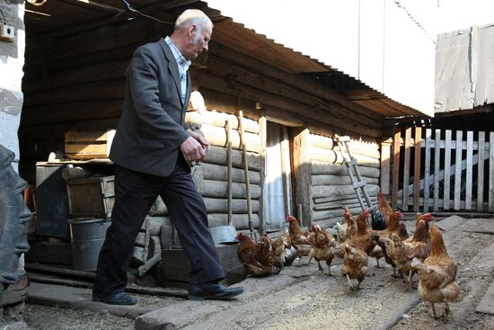Pugachevo villager feeds chickens