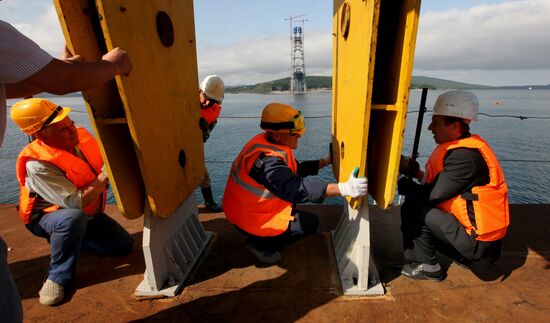 Preparing panel of bridge to Russky Island for elevation