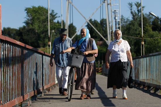 Shuya residents walk on pedestrian bridge over Teza River