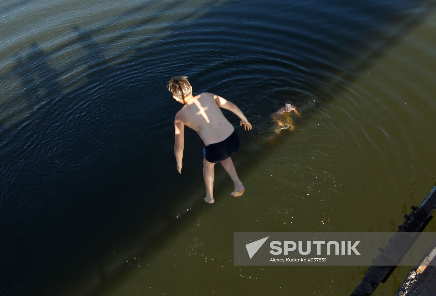 Boys jump off pedestrian bridge over Teza River in Shuya