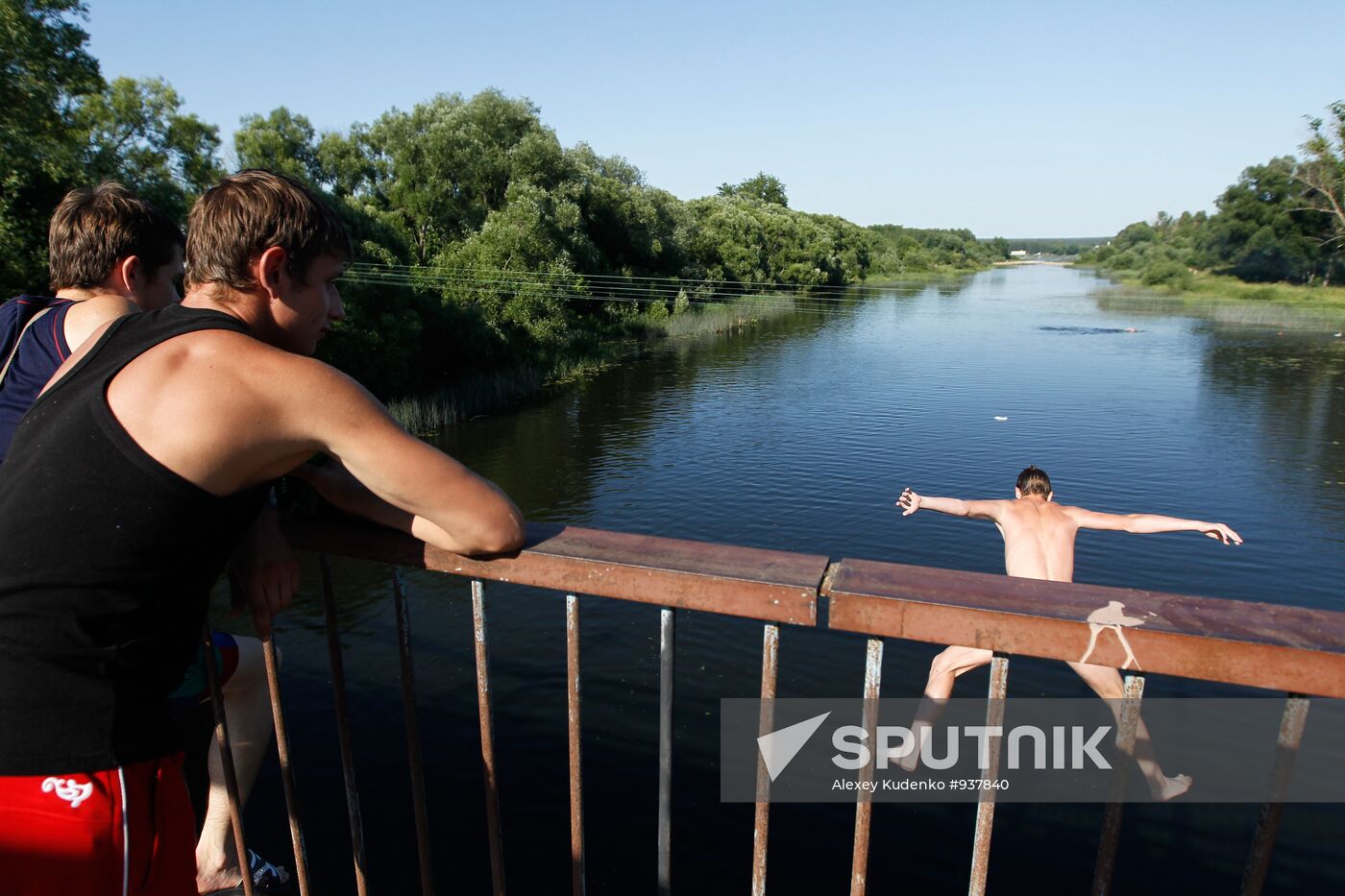 Boys jump off pedestrian bridge over Teza River in Shuya