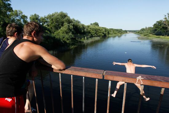 Boys jump off pedestrian bridge over Teza River in Shuya