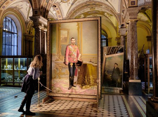 Preparing restored double-sided painting with portraits of Emperor Nicholas II and Vladimir Lenin for presentation at Stieglitz Academy