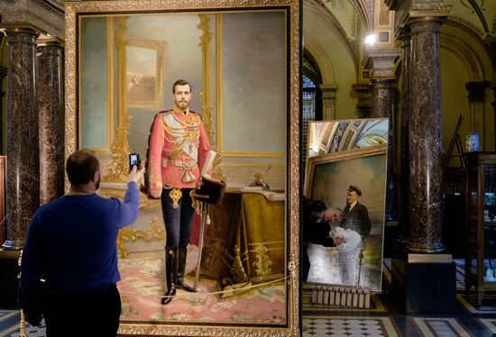 Preparing restored double-sided painting with portraits of Emperor Nicholas II and Vladimir Lenin for presentation at Stieglitz Academy
