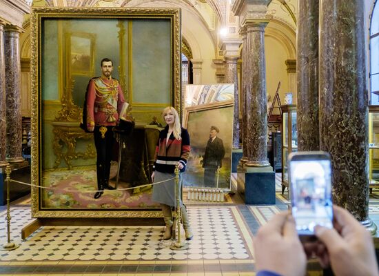 Preparing restored double-sided painting with portraits of Emperor Nicholas II and Vladimir Lenin for presentation at Stieglitz Academy