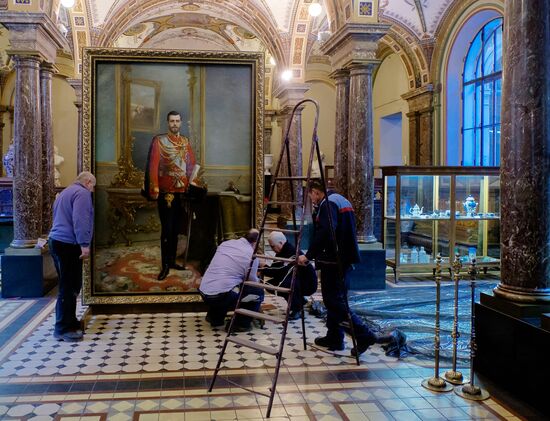 Preparing restored double-sided painting with portraits of Emperor Nicholas II and Vladimir Lenin for presentation at Stieglitz Academy