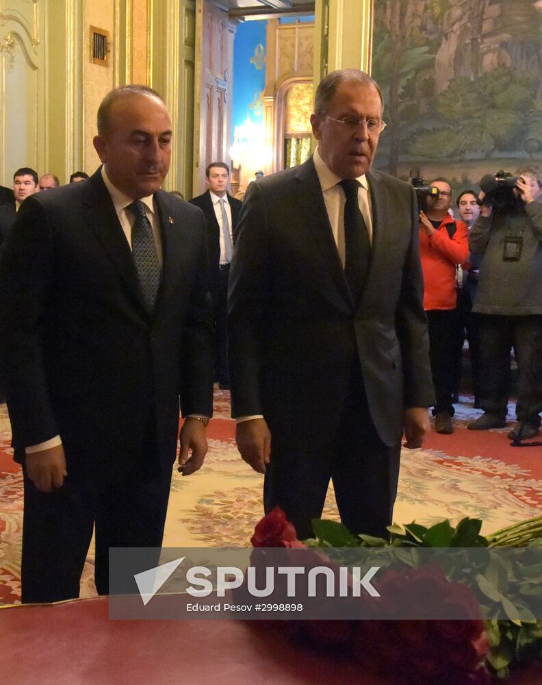 Foreign Minister Sergei Lavrov, right, and Turkish Foreign Minister Mevlut Cavusoglu lay flowers in memory of the assassinated Russian Ambassador to Turkey Andrei Karlov. Location: Russia, Moscow. Author: Eduard Pesov/Sputnik. Foreign ministers of Russia, Iran, Turkey lay flowers in memory of Ambassador Andrei Karlov