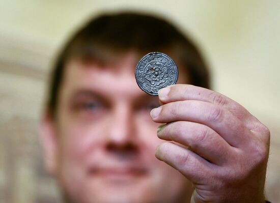 Displaying a 16th century medallion unearthed by archelogists at Zaryadye Park