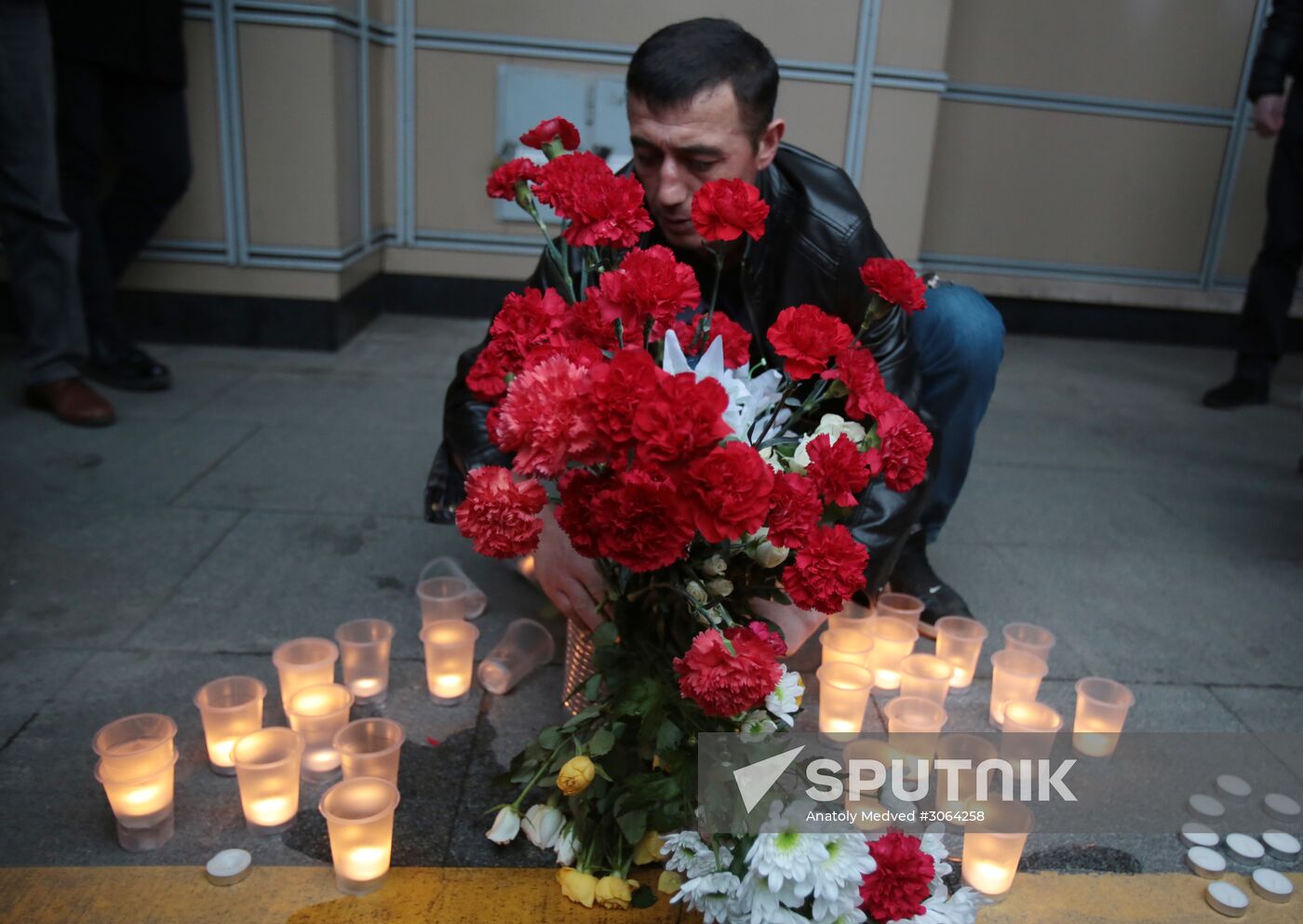 A man lays flowers at the entrance to the lobby of the Spasskaya metro station in memory of the St. Petersburg metro blast victims. Location: Russia, St. Petersburg. Author: Anatoly Medved/Sputnik. Flowers in memory of St. Petersburg metro blast victims