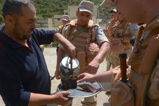 Servicemen of Russian center for reconciliation of the warring parties in Syria deliver humanitarian aid to Syrian village of Joubet Burghal