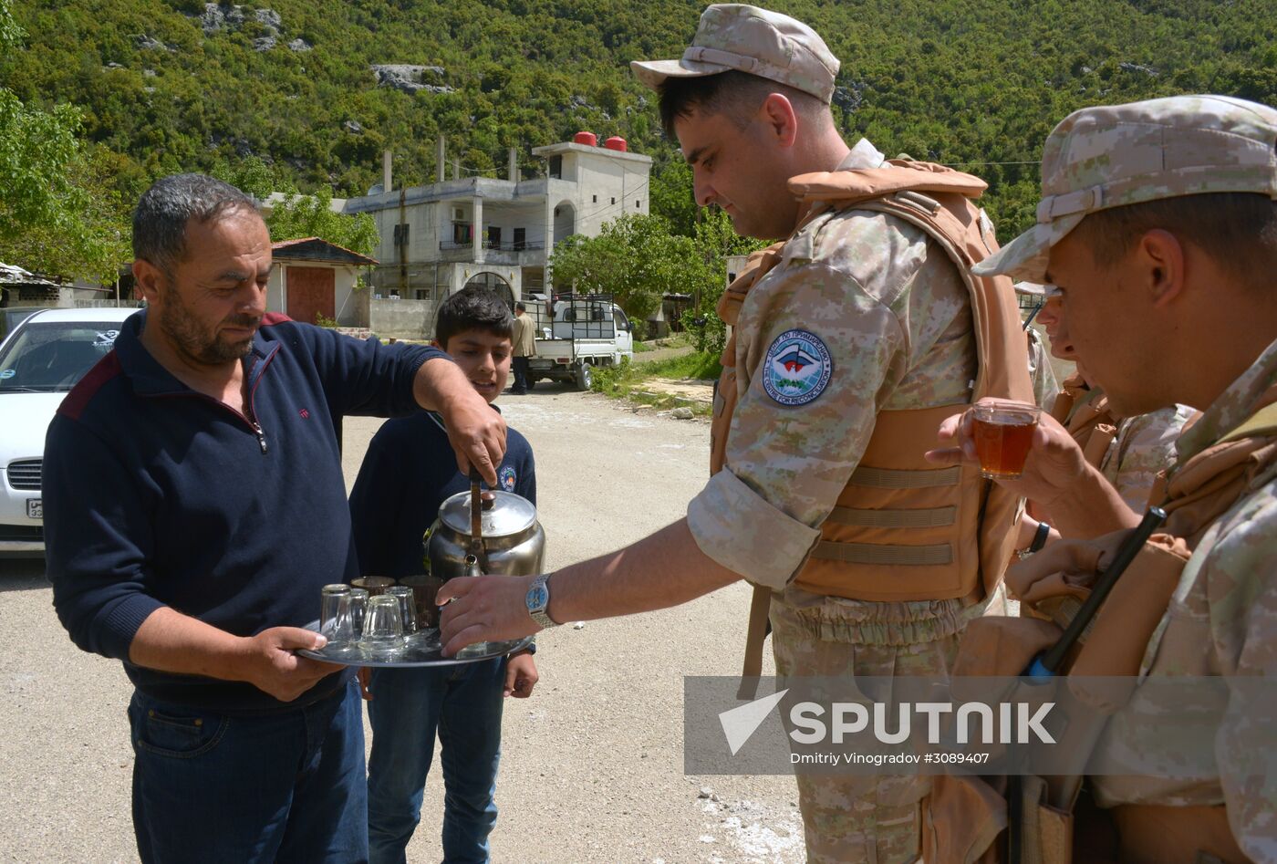Servicemen of Russian center for reconciliation of the warring parties in Syria deliver humanitarian aid to Syrian village of Joubet Burghal
