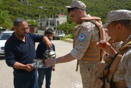 Servicemen of Russian center for reconciliation of the warring parties in Syria deliver humanitarian aid to Syrian village of Joubet Burghal
