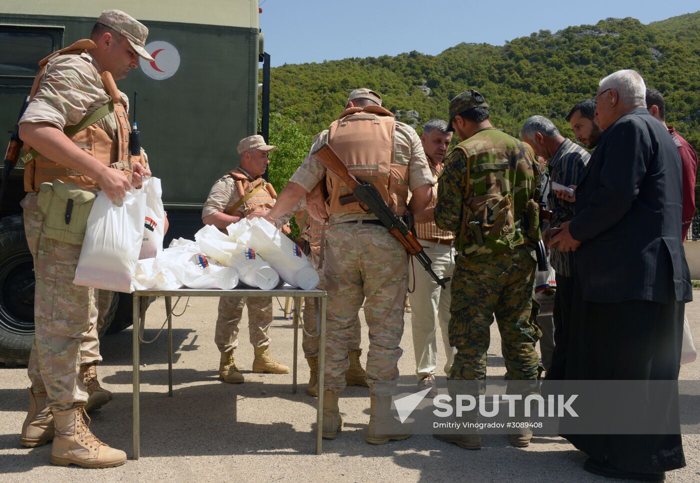 Servicemen of Russian center for reconciliation of the warring parties in Syria deliver humanitarian aid to Syrian village of Joubet Burghal