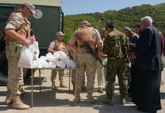 Servicemen of Russian center for reconciliation of the warring parties in Syria deliver humanitarian aid to Syrian village of Joubet Burghal