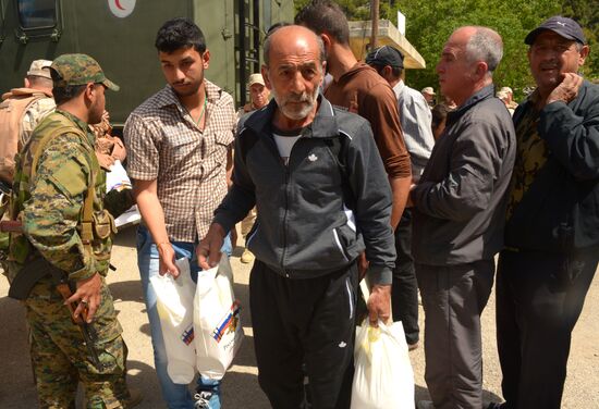 Servicemen of Russian center for reconciliation of the warring parties in Syria deliver humanitarian aid to Syrian village of Joubet Burghal