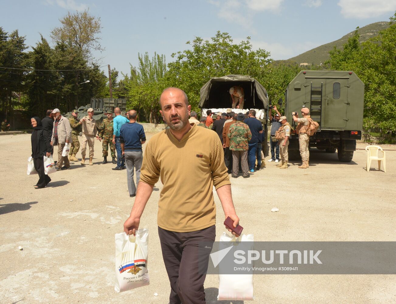 Servicemen of Russian center for reconciliation of the warring parties in Syria deliver humanitarian aid to Syrian village of Joubet Burghal