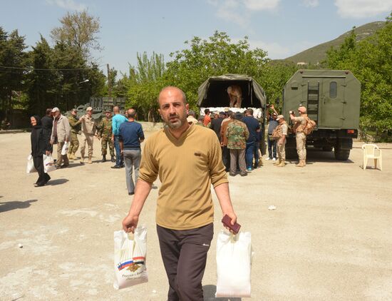 Servicemen of Russian center for reconciliation of the warring parties in Syria deliver humanitarian aid to Syrian village of Joubet Burghal