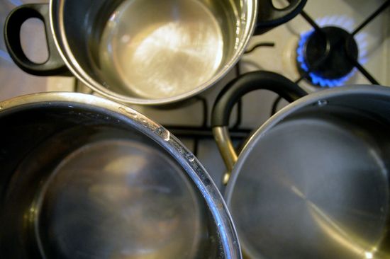 Pots with water on gas stove